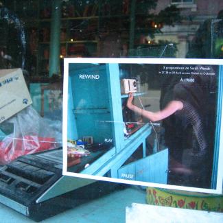 Affichette de Rewind, Play, Pause dans la vitrine du commerce P. Gillman